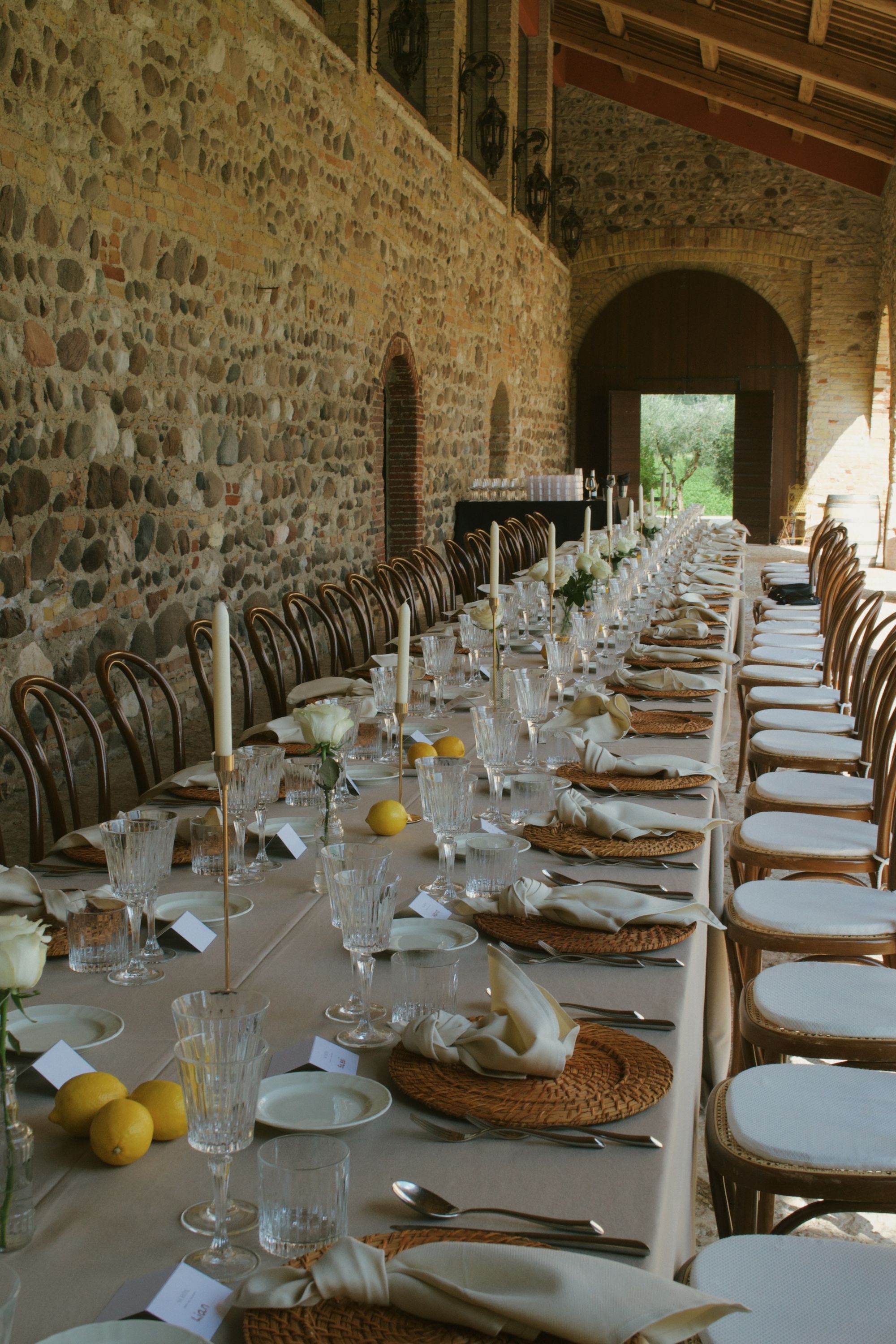 An elegant long dining table set for a group gathering in a stone-arched venue